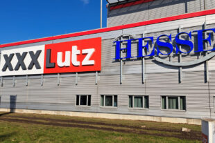 Leuchtschriften bei Tag an der Fassade des XXXLutz in Garbsen, Deutschland