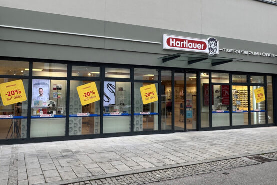 Leuchtschilder und Leuchtschriften an der Fassade der Hartlauer Filiale in Grieskirchen