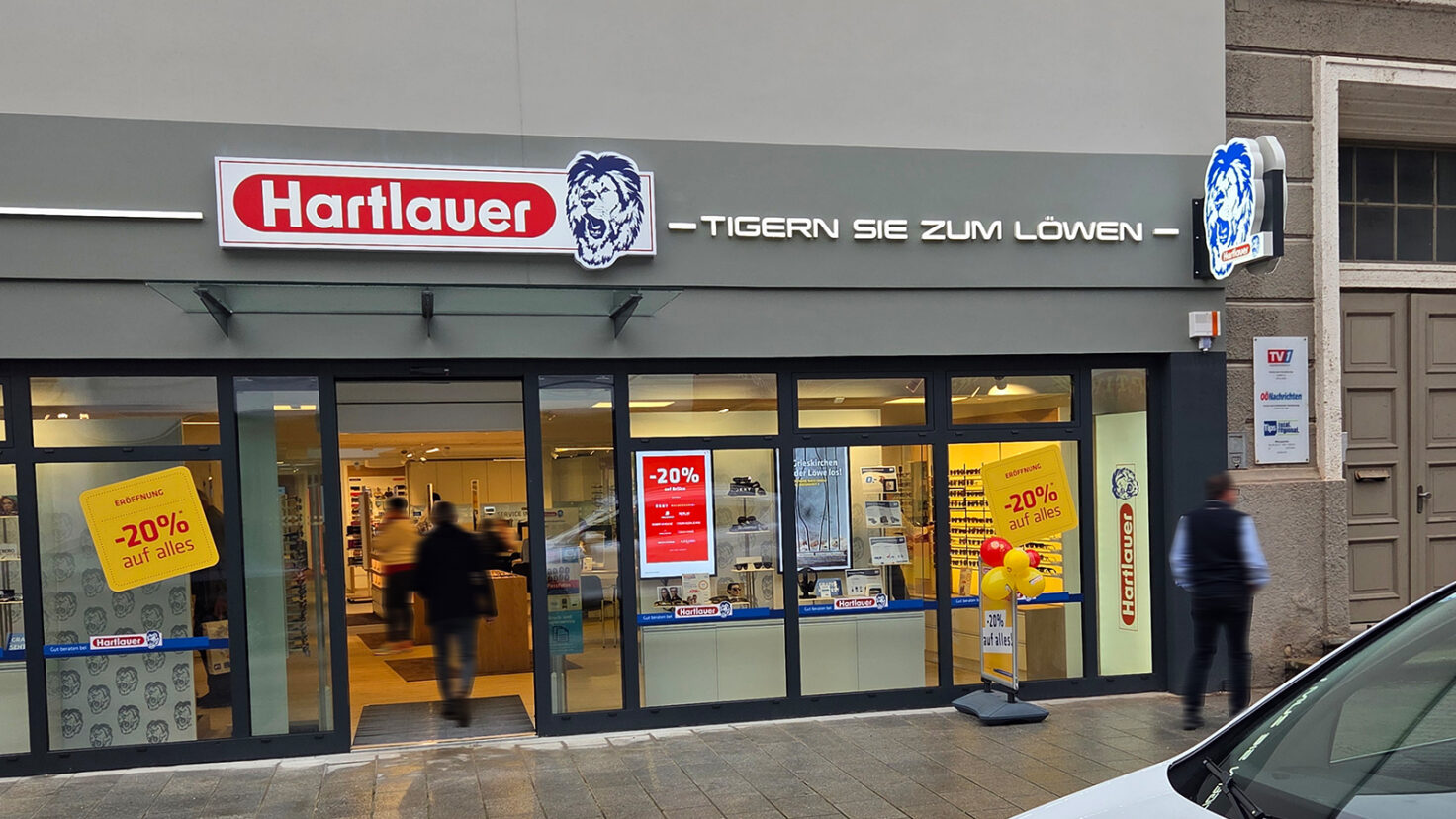 Leuchtschilder und Leuchtschriften an der Fassade der Hartlauer Filiale in Grieskirchen