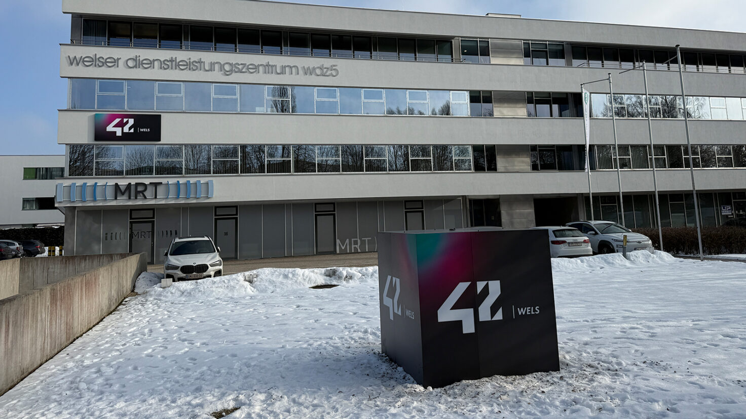 Leuchtender Würfel und Fassaden-Leuchtschild beim Campus 42 in Wels