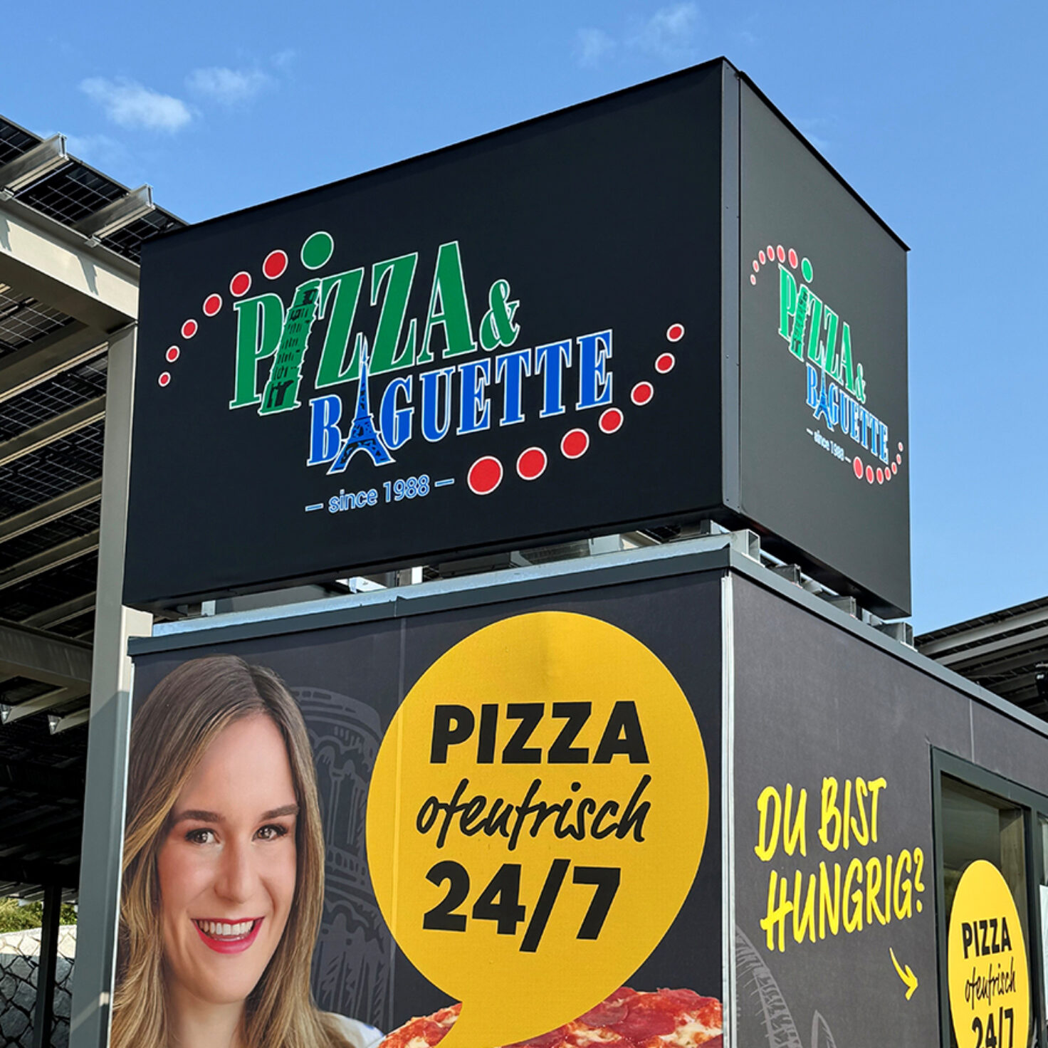 Leuchtschilder am Dach eines Containers der Pizza-Baguette GmbH