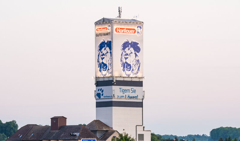 Hartlauer Werbeturm Enns Bespannung Bespannung mit Transparenten eines Mühlenturms von HUBER Signage