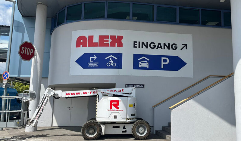 Werbeschild unbeleuchtet beim Shoppingcenter Alex in Krems an der Fassade
